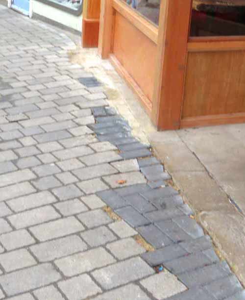 The workmanship of pavement repairs at the entrance to Guns and Smoke typifies the casual approach to this site by both the landlord and tenant