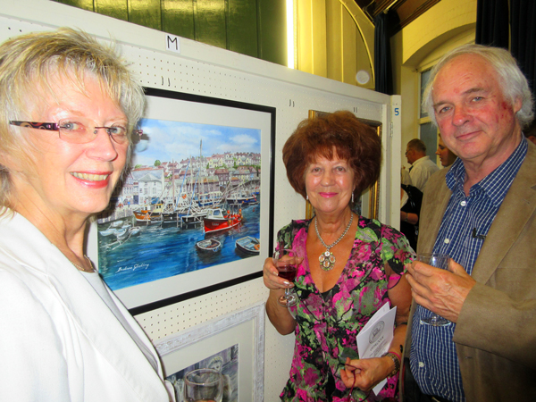 Barbara Gladding (centre), a long-standing member of the Barnet Guild of Artists, with her watercolour of Mevagissey, one of her five painting on display at the Guild’s 68th annual exhibition. With her are friends, Elaine Padmore and Grant Shelley